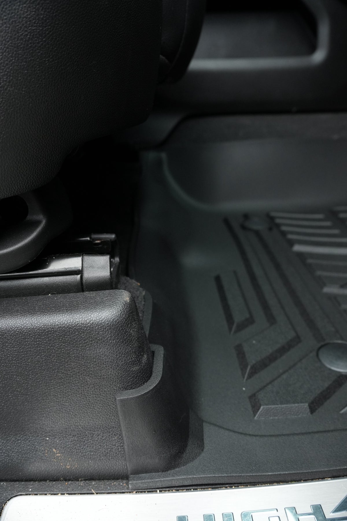 RevTread mat edge fitting tight against the seat base of a Silverado High Country